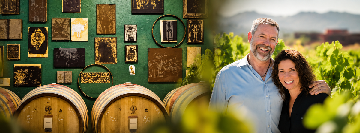 Sine Qua Non winery barrels and artwork alongside founders Manfred and Elaine Krankl in a California vineyard